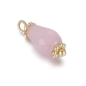 Macro shot of faceted pink teardrop gemstone pendant with gold-plated metal caps