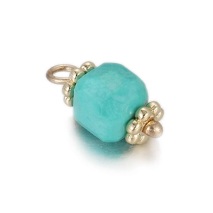 Macro detail of geometric turquoise stone pendant with golden flower caps and closed ring