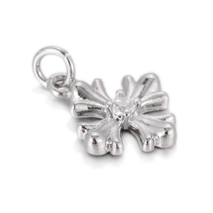 Macro shot of silver cross charm with centered round white zircon and polished finish