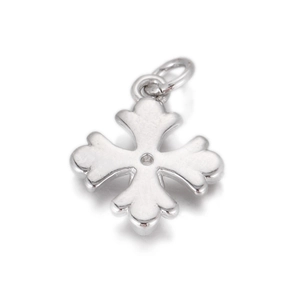Macro shot of a silver vintage cross pendant with wavy edges and a polished finish