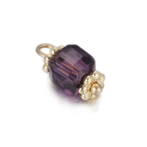 Macro detail of purple faceted crystal pendant with golden petal-shaped metal caps