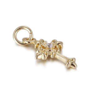 Macro shot of 14k gold-plated cross pendant with a central sparkling zircon inlay