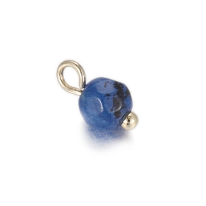 Detailed close-up of a blue lapis lazuli round stone pendant with silver metal hanging loop