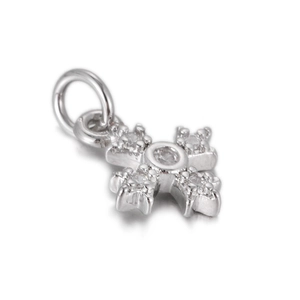 Macro detail of a silver cross pendant with cubic zirconia inlay on white backdrop
