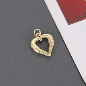 Colgante de corazón dorado con texturas de alas y lazo para creación de joyas DIY
