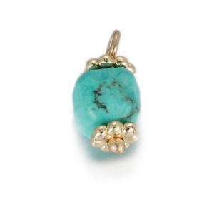 Macro-detail van de turquoise cilinder hanger met gouden kralen en natuurlijke textuur