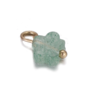 Macro detail of a light green four-leaf clover natural stone pendant with a gold metal ring