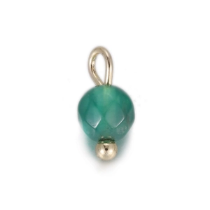Macro detail van een gefacetteerde donkergroene edelsteen hanger met gouden metalen oog
