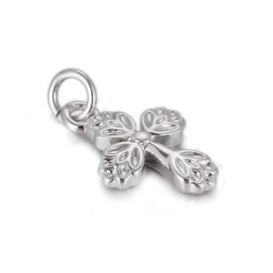 Macro detail of silver cross pendant with intricate relief texture and vintage relief style