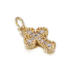 Macro view of a 14k gold plated cross pendant featuring sparkling white zircon stones
