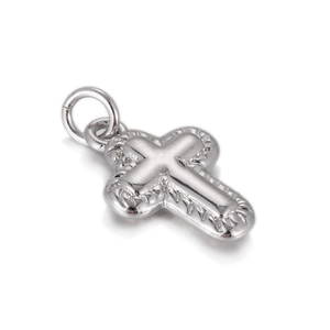 Macro view of double-layered silver cross pendant with polished finish and engraved texture