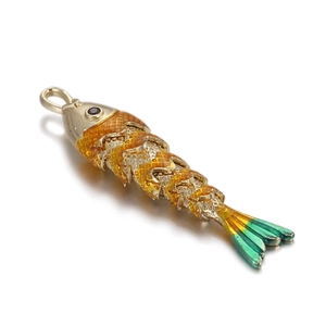 Macro shot of flexible koi carp fish pendant with orange enamel scales and gold plating
