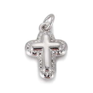 Macro shot of silver layered cross pendant with scalloped edges and polished finish