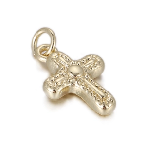 Macro detail of a 14k gold plated cross pendant with vintage relief texture and round bail