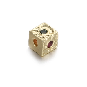 Macro detail of cube charm with hammered gold texture and multi-colored gemstones
