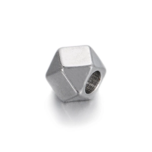 Close-up of geometric faceted silver metal bead with central hole for DIY jewelry making
