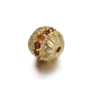 Detail of 14K gold hollow spherical bead with red zircon inlays for DIY jewelry