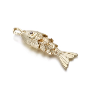 Close-up of golden articulated fish pendant with intricate scales and dark gem eye