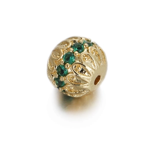 Macro detail of 14k gold plated hollow bead with green zircon stones for DIY jewelry