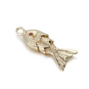 Detailed view of flexible gold fish pendant with red zircon eye and articulated body scale