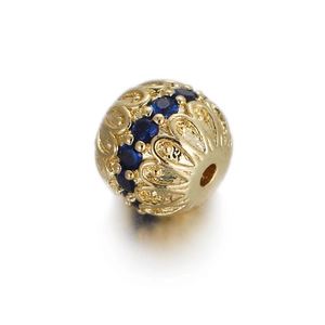 Macro shot of 14k gold plated hollow flower bead with blue zircon stone inlay detail