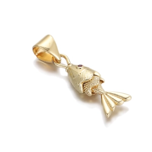Macro shot of a golden fish pendant with scale texture and a small red stone eye