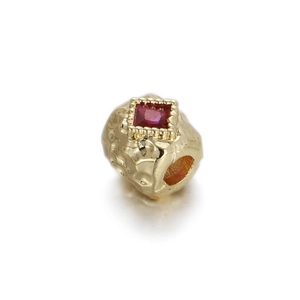 Detail of 14K gold plated bead with hammered texture and a square red zircon stone inlay
