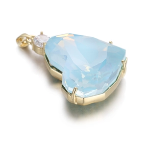 Détail d'un pendentif coeur en zircon bleu clair avec cadre doré et diamant d'accentuation