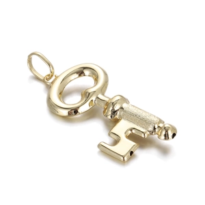 Macro detail of 14k gold plated brass key pendant charm for jewelry making