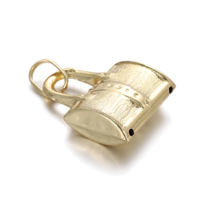 Macro shot of 14k gold-plated handbag charm with textured finish and rivet details