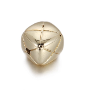 Macro shot of 14k gold-plated metal bead with engraved cross patterns for jewelry making