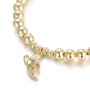 Exaggerated golden bead bracelet featuring a smooth polished banana-shaped metal charm