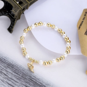 Golden beads and white pearls bracelet with a shell charm on a vintage romantic background