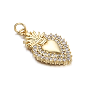 Detailed macro view of a golden Sacred Heart pendant with sparkling zircon accents