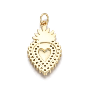 Macro detail of gold-plated sacred heart pendant with intricate crown and ray textures