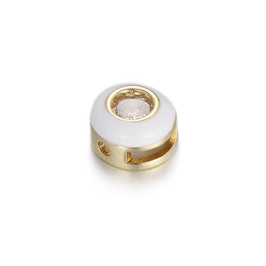 Macro view of 14K gold plated heart palm bead with white enamel and clear zircon stone