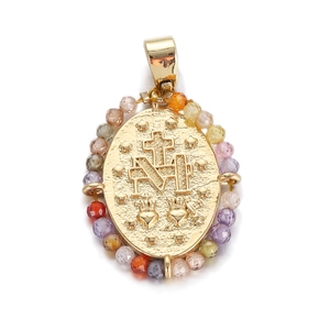 Macro detail of oval gold religious pendant with cross, M letter, and colorful beads