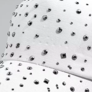 Macro detail of white baseball cap with multi-shaped dark rhinestones and premium fabric