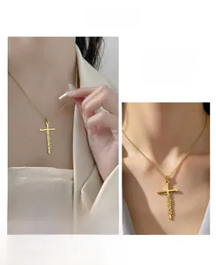 Close-up of gold cross pendant with patience script lettering on model neck