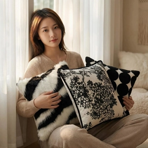 Coussins décoratifs scandinaves en peluche noir et blanc sur un canapé lumineux