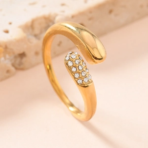 Gold plated open bypass ring with a polished metal sphere and pavé zircon accents