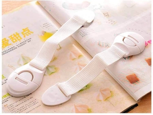 Close-up of baby safety strap locks for cabinets and drawers on a wooden surface