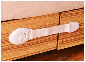 Close-up of white baby safety strap lock installed on a wooden drawer for childproofing
