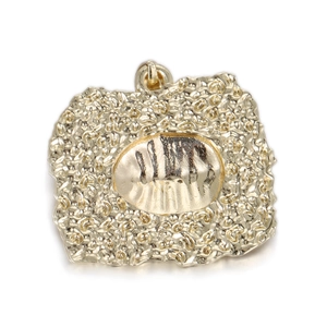 Detailed view of vintage gold brass pendant with irregular hammered texture and oval center