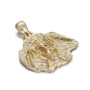 Detailed close-up of golden skeleton fossil pendant with intricate textured punk design