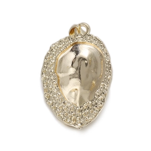 Macro shot of gold punk dinosaur fossil pendant featuring polished mirror and textured edges