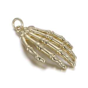 Detailed close-up of golden skeletal hand charm featuring textured metal finger bones