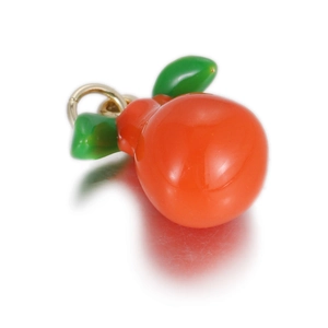 Macro-opname van oranje vrucht hanger met groene bladeren en gouden ring voor sieraden