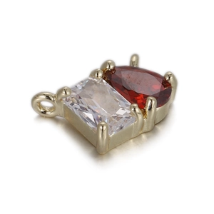 Détail du pendentif doré avec zircone rouge en poire et zircone claire taille émeraude