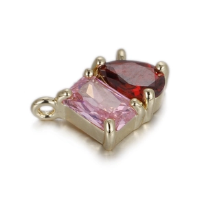 Détail de breloques en cristal rose et rouge avec monture dorée et anneau de liaison